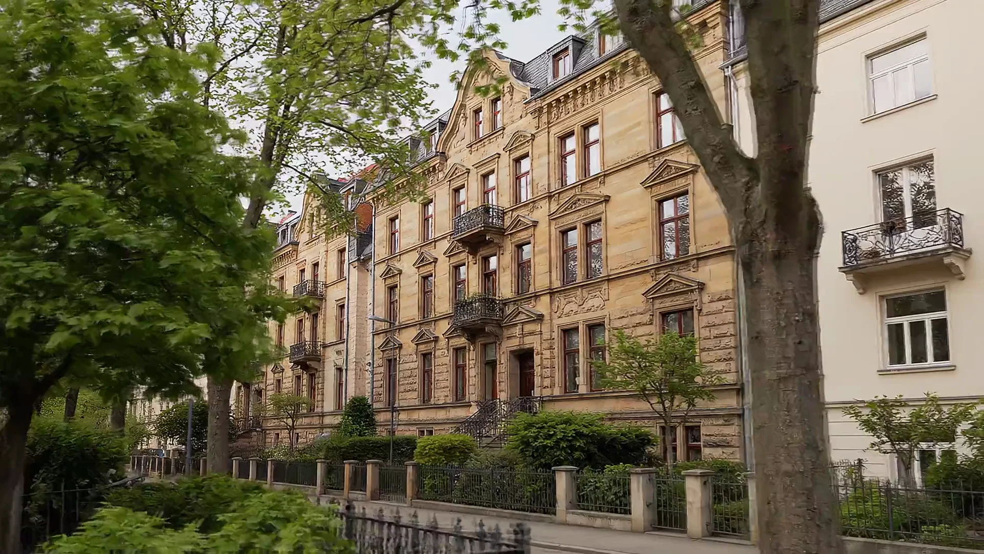 Illustrative Gründerzeit-Fassaden und begrünte Wohnstraße in Dresden